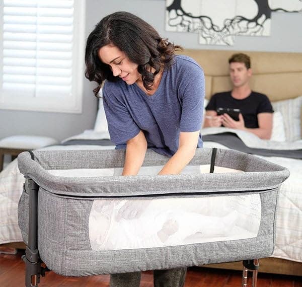 mom picking baby from Mika Micky Bedside Sleeper Easy Folding Portable Crib