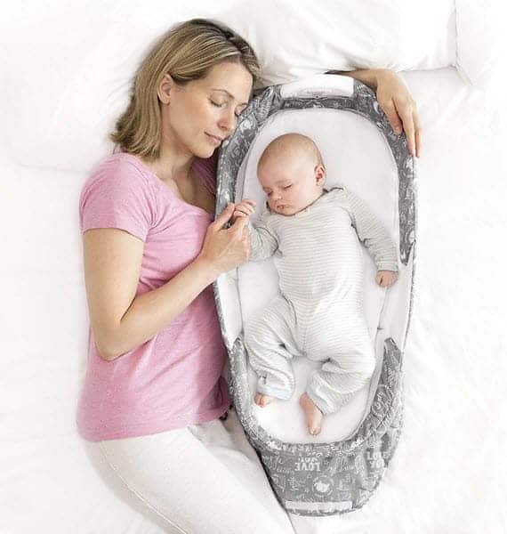 mom sleeping with Baby Delight Snuggle Nest Harmony Infant Sleeper