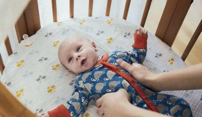 mom holding a baby in the crib