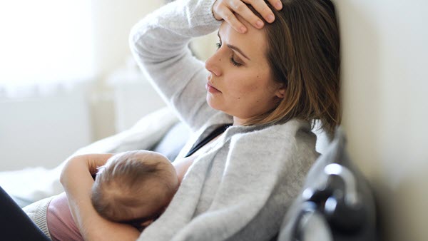 mom doing breastfeeding and feeling tired